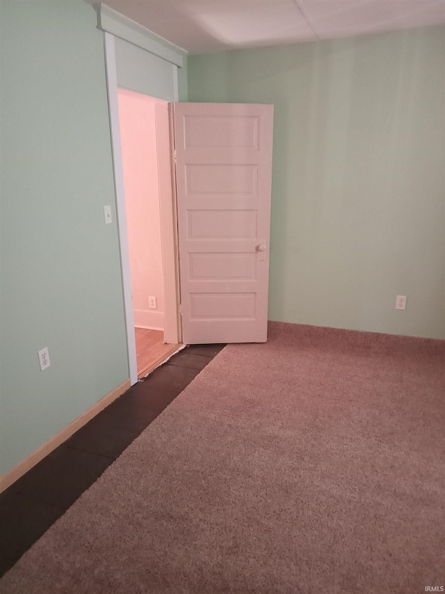 spare room featuring dark carpet