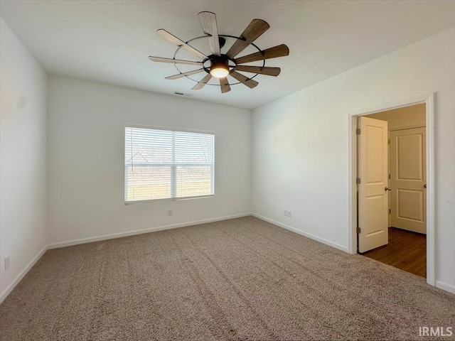 spare room with dark colored carpet and ceiling fan