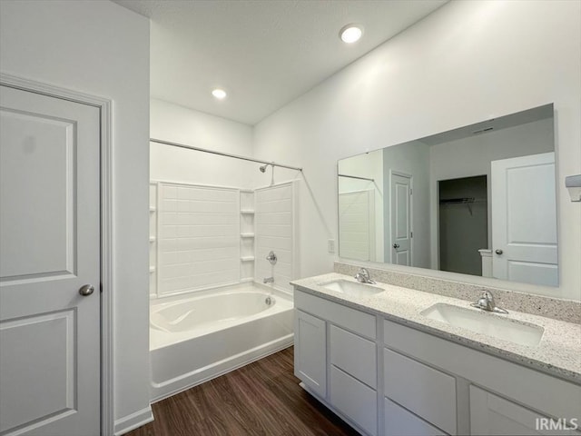 bathroom featuring vanity, wood-type flooring, and washtub / shower combination