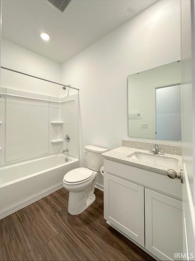 full bathroom with shower / bath combination, wood-type flooring, vanity, and toilet