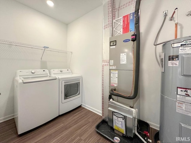 washroom featuring washer and dryer, hardwood / wood-style floors, and water heater