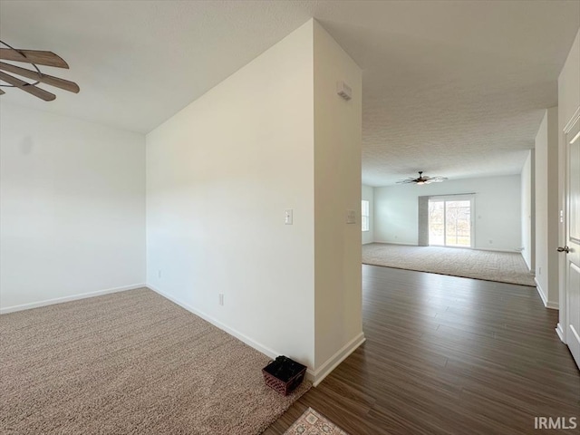 empty room featuring dark wood-type flooring, ceiling fan, and a textured ceiling