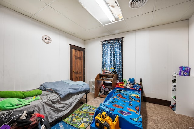 bedroom with carpet floors and a drop ceiling