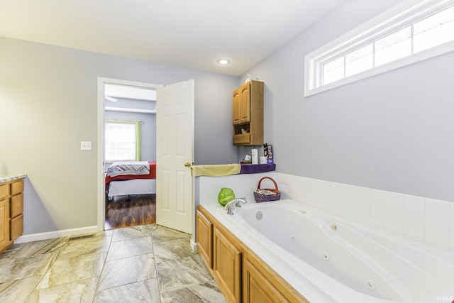 bathroom with plenty of natural light, vanity, and a tub