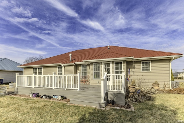 rear view of house with a deck and a lawn