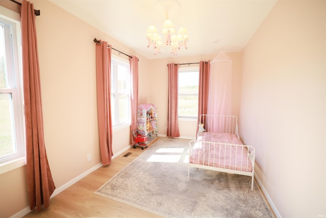 unfurnished bedroom featuring light hardwood / wood-style flooring and a chandelier