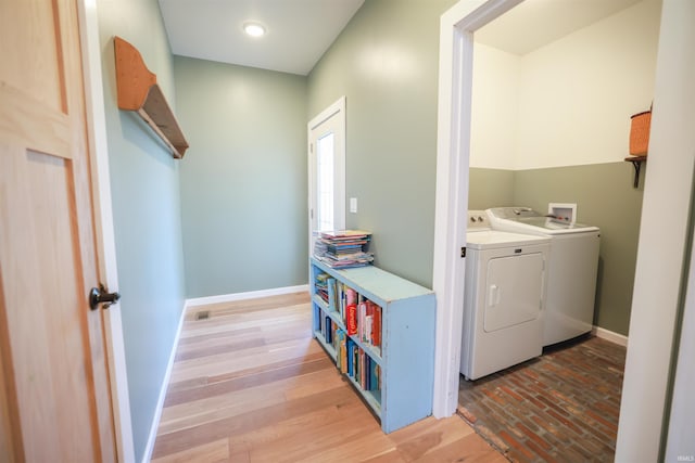 laundry area with hardwood / wood-style floors and washing machine and dryer