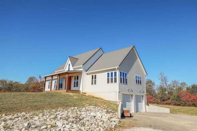 view of front of home with a garage, a front lawn, and a porch