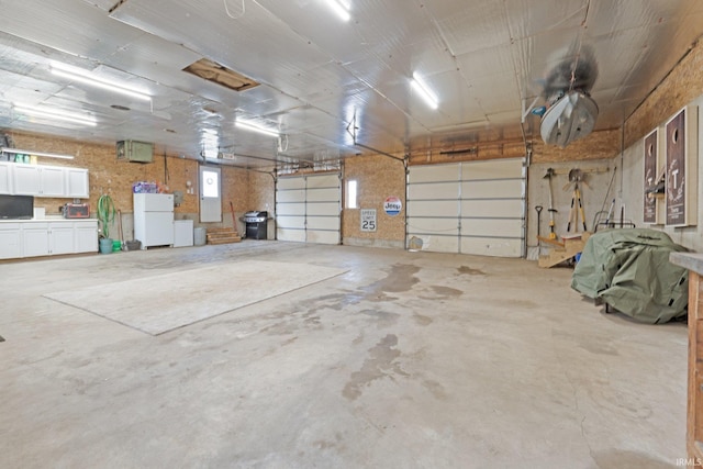 garage featuring white fridge and electric panel