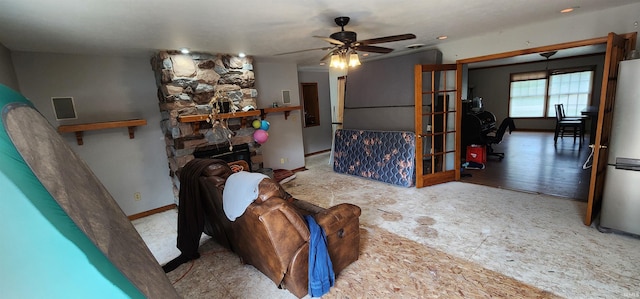 living room with a fireplace and ceiling fan