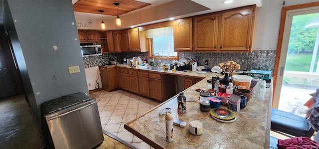 kitchen with pendant lighting, sink, tasteful backsplash, and light tile patterned flooring