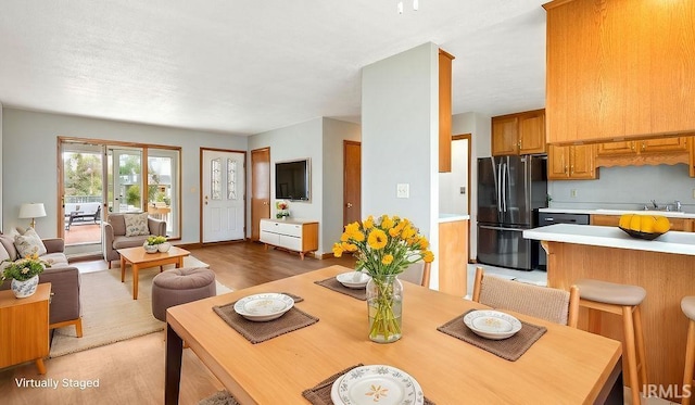 dining room with sink and light hardwood / wood-style flooring