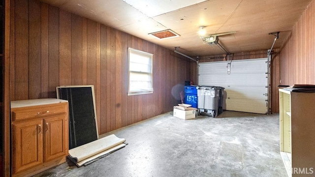 garage featuring a garage door opener and wood walls