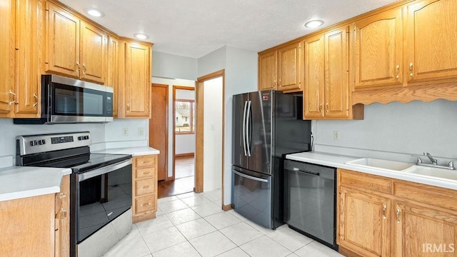 kitchen featuring stainless steel appliances, sink, and light tile patterned floors