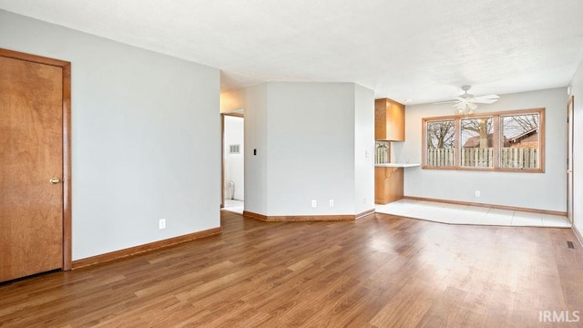 unfurnished living room featuring hardwood / wood-style flooring and ceiling fan