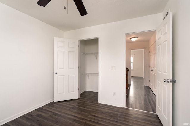 unfurnished bedroom featuring dark wood-type flooring, ceiling fan, and a closet