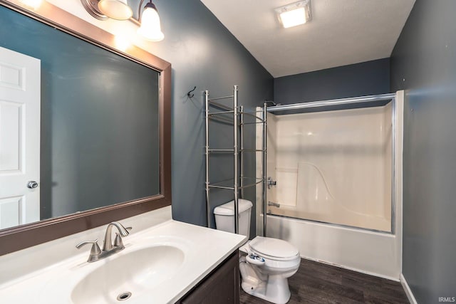 full bathroom with bath / shower combo with glass door, hardwood / wood-style floors, vanity, and toilet