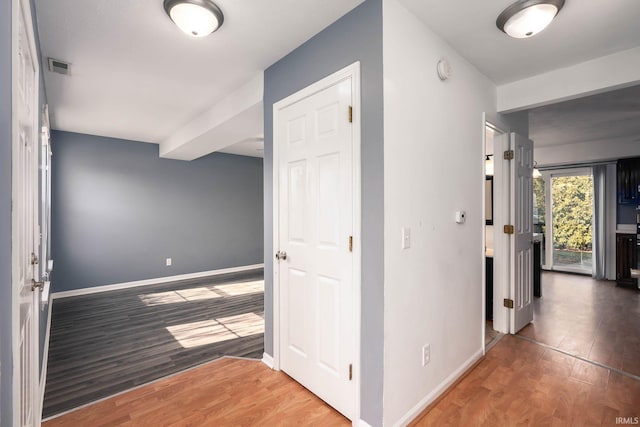 corridor with hardwood / wood-style flooring