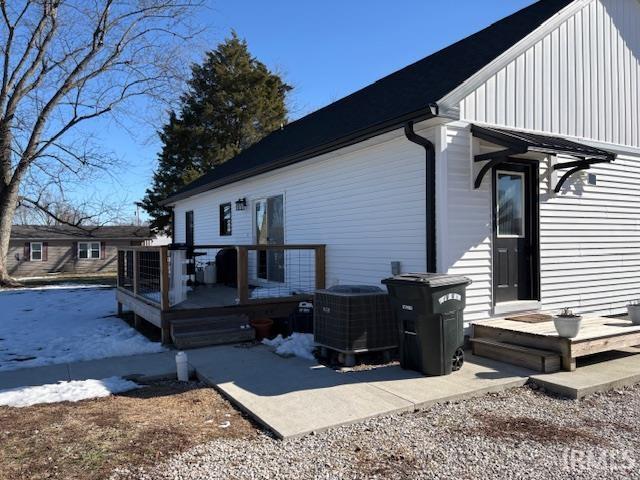 rear view of property featuring a wooden deck and cooling unit