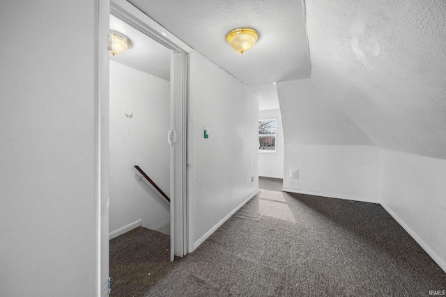 bonus room featuring vaulted ceiling, dark carpet, and a textured ceiling