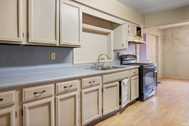 kitchen featuring black electric range oven, cream cabinets, sink, and light wood-type flooring