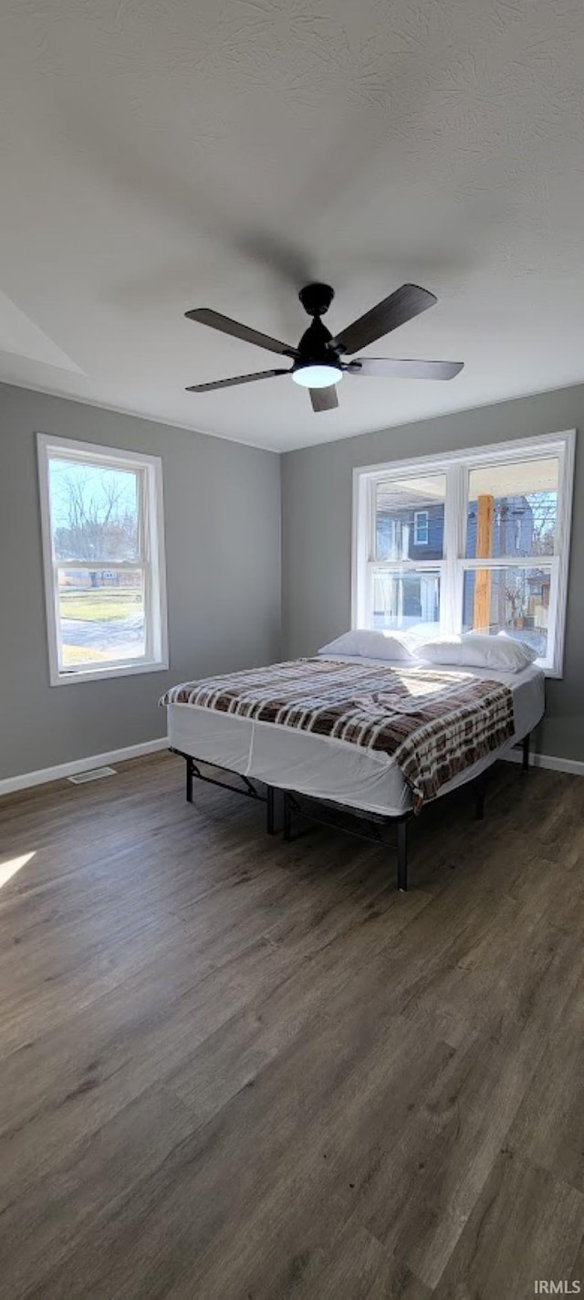 unfurnished bedroom with dark wood-type flooring and ceiling fan