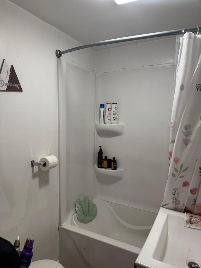 full bathroom with shower / tub combo with curtain, sink, and toilet