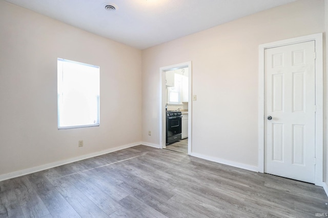 empty room with light hardwood / wood-style flooring and a healthy amount of sunlight