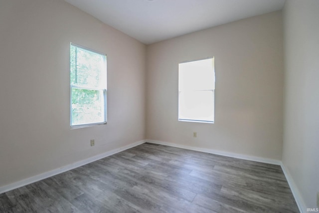 unfurnished room with dark hardwood / wood-style flooring