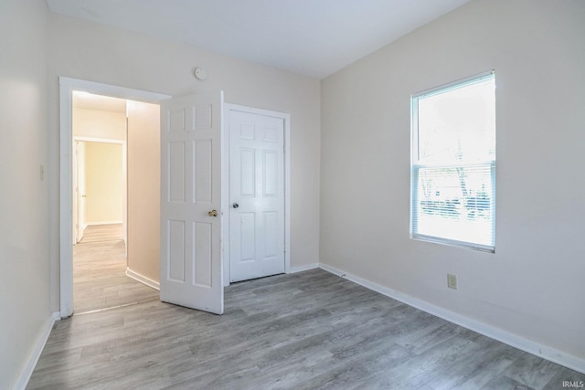 unfurnished bedroom with wood-type flooring and a closet