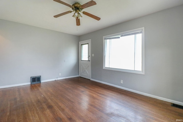 spare room with dark wood-type flooring and ceiling fan