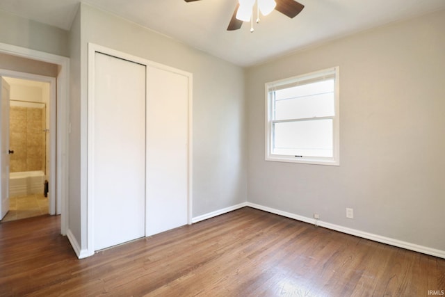 unfurnished bedroom with hardwood / wood-style floors, a closet, and ceiling fan