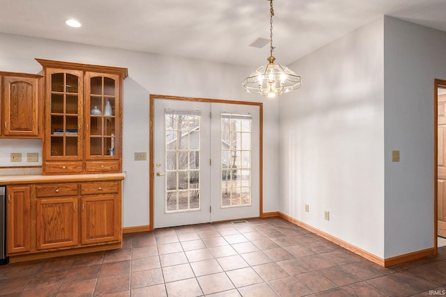 unfurnished dining area featuring a notable chandelier and dark tile patterned flooring