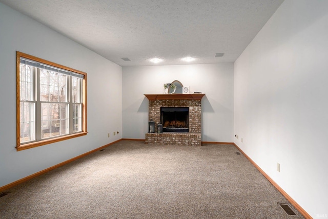 unfurnished living room with a fireplace, a textured ceiling, and carpet