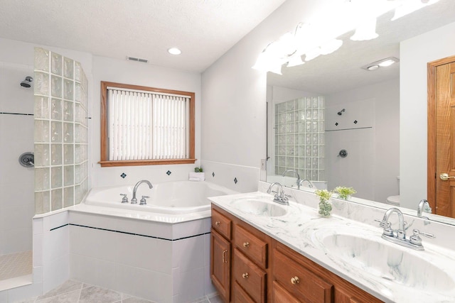 full bathroom featuring plus walk in shower, tile patterned flooring, vanity, toilet, and a textured ceiling