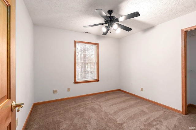 spare room featuring ceiling fan, carpet floors, and a textured ceiling