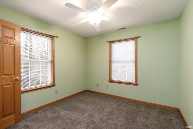 carpeted spare room with ceiling fan and a textured ceiling