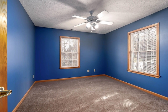 carpeted spare room featuring ceiling fan and a textured ceiling