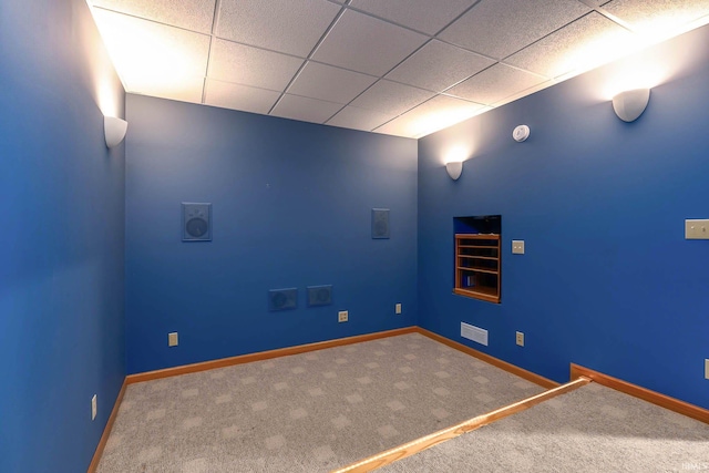 interior space featuring a paneled ceiling and carpet