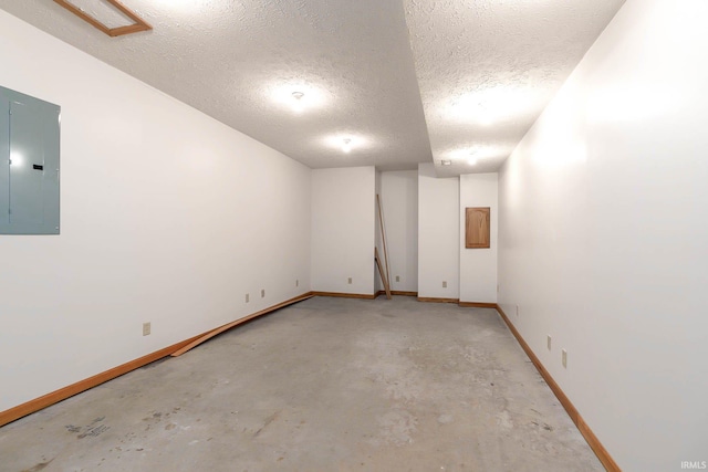 spare room featuring electric panel and a textured ceiling