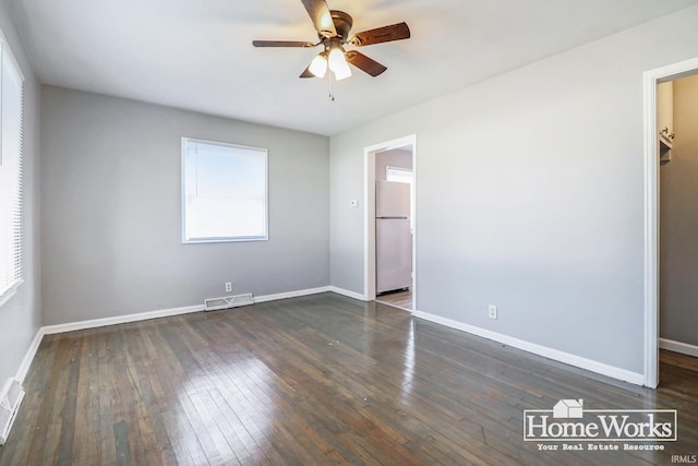 empty room with dark hardwood / wood-style floors and ceiling fan