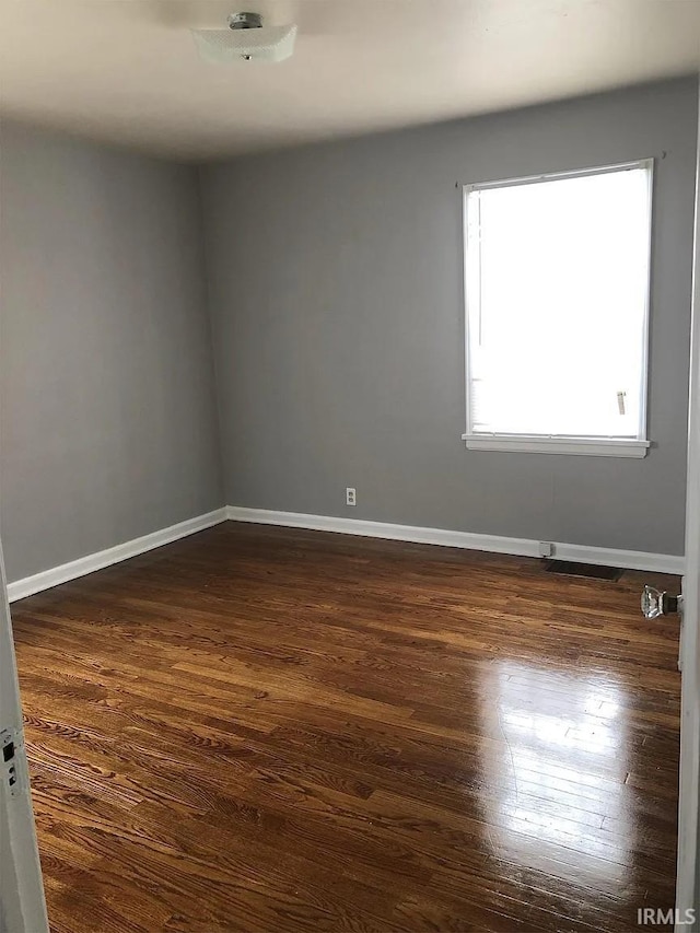 spare room featuring dark hardwood / wood-style flooring