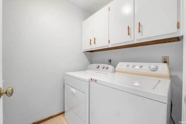 laundry area featuring separate washer and dryer and cabinets