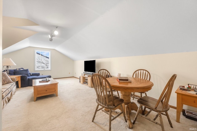 carpeted dining space featuring lofted ceiling