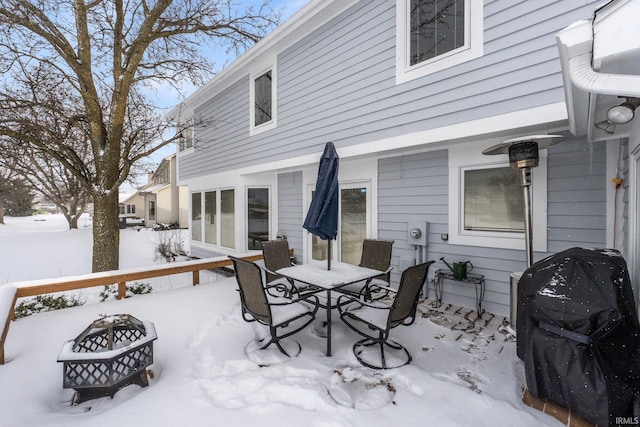 snow covered deck with grilling area and an outdoor fire pit