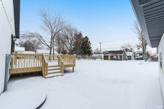 yard covered in snow with a wooden deck