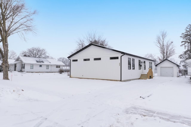 snow covered property with an outbuilding and a garage