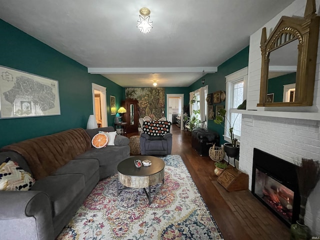 living room with beamed ceiling, dark wood-type flooring, and a fireplace