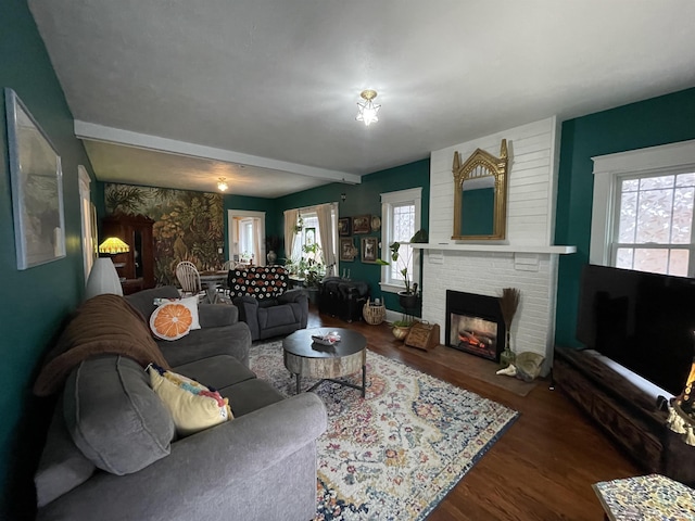 living room with dark hardwood / wood-style flooring and a brick fireplace