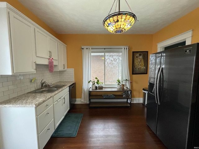 kitchen with pendant lighting, white cabinetry, dishwasher, sink, and stainless steel refrigerator with ice dispenser